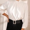 Blusa unicolor de cuello alto con botón